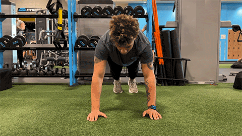 eos member performing push-ups with shoulder tap